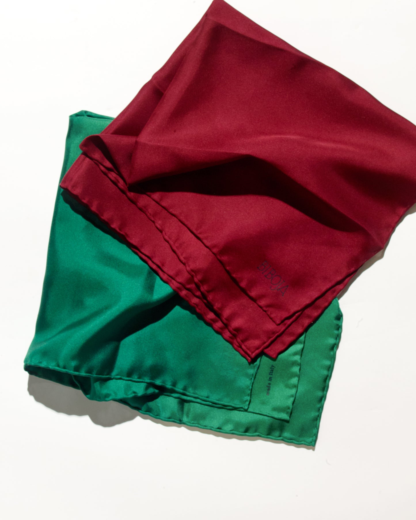 Red and green squared scarves in silk fabric on a white background