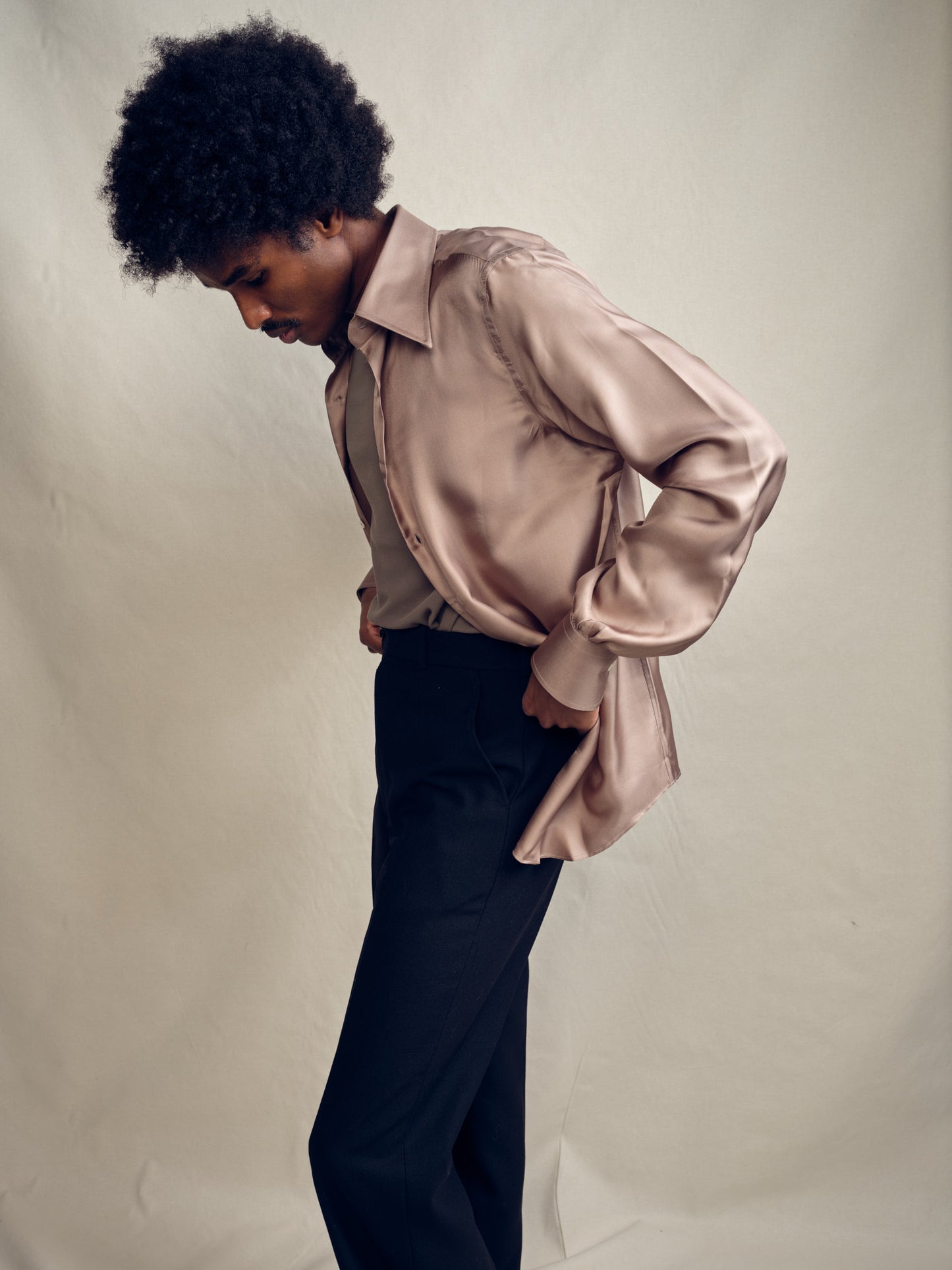 Model wearing Biboja champagne beige silk shirt with signature house collar, single cuffs, made in Italy, side view.