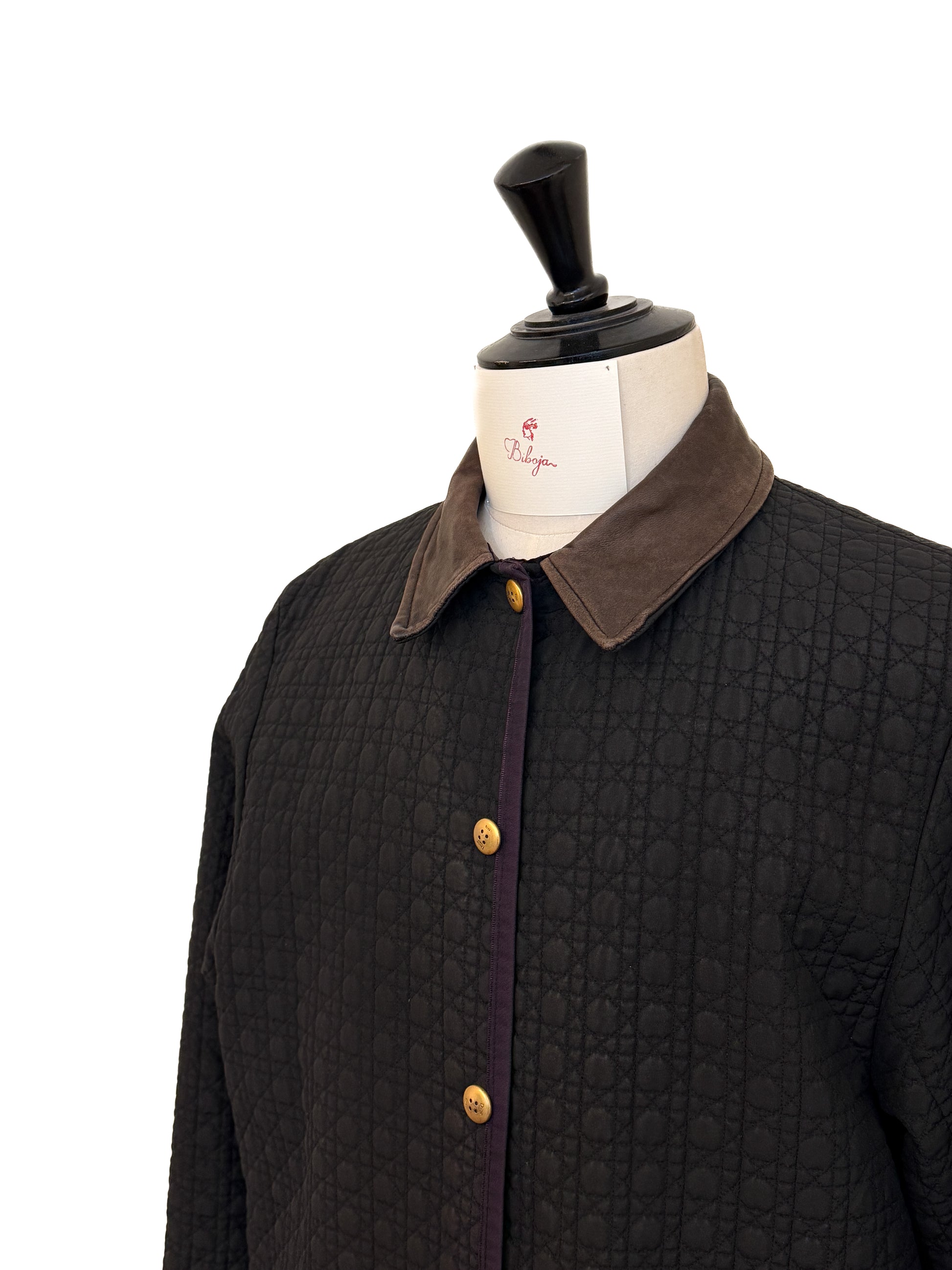 Dark quilted jacket with brown collar on a mannequin against a white background