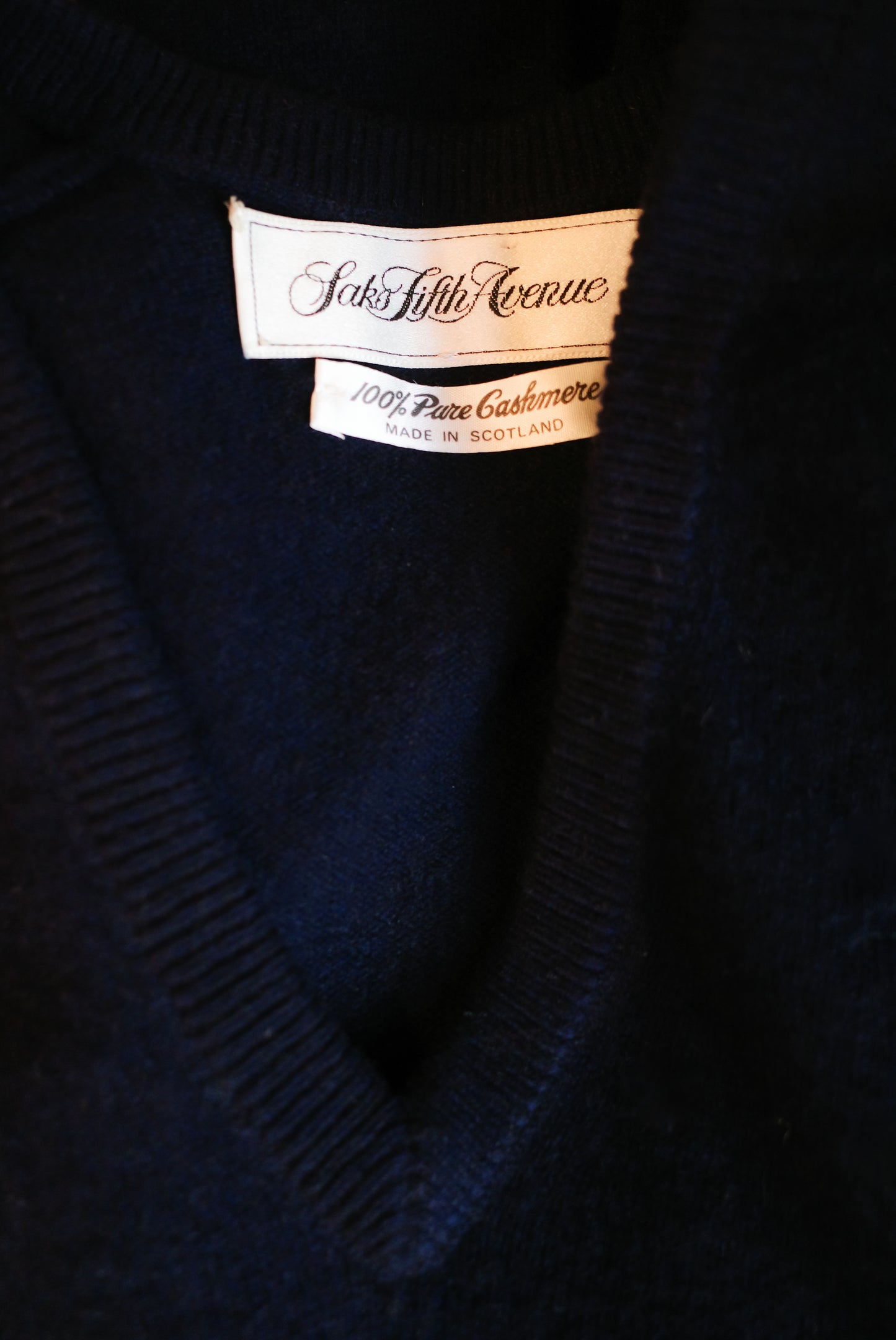 Close-up of a vintage Saks Fifth Avenue navy blue v-neck sweater. Cashmere, made in Scotland