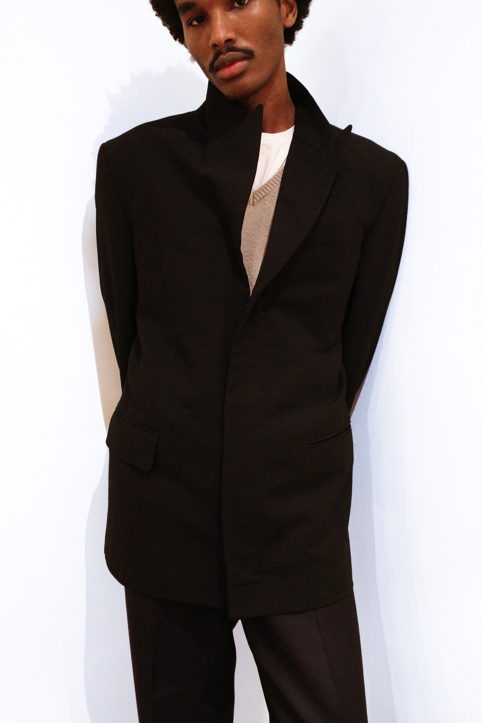 Person wearing a vintage Comme des Garçons Homme blazer over a white shirt on a white background